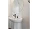 Close up of a pedestal sink with an oval mirror in a bathroom at 9237 Truckee Ct, Commerce City, CO 80022