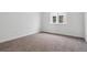 A bright bedroom with a large window and neutral carpet at 9237 Truckee Ct, Commerce City, CO 80022