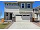 Two-story home showcasing a two car garage and a black front door with stone accents at 9237 Truckee Ct, Commerce City, CO 80022