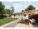 Backyard showcases a green lawn, patio with umbrella, and neutral building, creating an inviting outdoor retreat at 3039 W Denver Pl, Denver, CO 80211