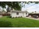 A spacious backyard features a large grassy area, neutral building, patio with furniture and an umbrella for outdoor relaxation at 3039 W Denver Pl, Denver, CO 80211