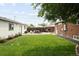 Expansive backyard features a lush lawn, privacy fence, additional building, and patio with an umbrella, creating a private outdoor oasis at 3039 W Denver Pl, Denver, CO 80211