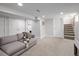 A finished basement with light grey walls, carpet, a sofa, and access to a staircase, offering a cozy and versatile living space at 3039 W Denver Pl, Denver, CO 80211