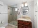 This bathroom has a glass door shower and a sink with tan granite countertops and an oval mirror above at 3039 W Denver Pl, Denver, CO 80211