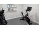 Home gym featuring a Peloton exercise bike and storage shelves at 3039 W Denver Pl, Denver, CO 80211