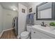 Well-lit bathroom featuring a modern vanity, toilet, and convenient laundry area at 5253 S Jericho St, Centennial, CO 80015