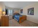 Comfortable bedroom with a wood frame bed, dresser, and natural light from the window at 5253 S Jericho St, Centennial, CO 80015