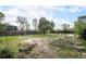 Spacious backyard featuring mature trees, wooden fence, and garden beds ready for planting at 547 S 3Rd Avenue, Brighton, CO 80601