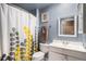 Bright bathroom featuring stylish shower curtain, white vanity and mirror at 547 S 3Rd Avenue, Brighton, CO 80601