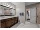 Modern bathroom featuring double vanity, granite countertops, and a glass-enclosed shower with stylish tile work at 15220 E Caley Ave, Centennial, CO 80016
