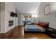 Modern bedroom featuring a stone fireplace, exercise equipment, and ample natural light from the large window at 15220 E Caley Ave, Centennial, CO 80016