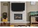 Living room fireplace with stone surround and an entertainment center, illuminated by natural light at 15220 E Caley Ave, Centennial, CO 80016