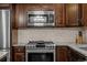 Stainless steel gas range stove and microwave in kitchen with granite countertops at 15220 E Caley Ave, Centennial, CO 80016
