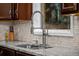 Close-up of kitchen sink with stainless steel faucet and granite countertops at 15220 E Caley Ave, Centennial, CO 80016