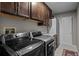 Well-equipped laundry room with modern washer and dryer, ample storage cabinets and granite countertops at 15220 E Caley Ave, Centennial, CO 80016