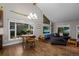 Open-concept living and dining area with large windows and hardwood floors. Vaulted ceilings and modern chandelier at 15220 E Caley Ave, Centennial, CO 80016
