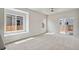 Bright living room featuring sliding glass doors, large windows, and plush carpeting at 709 Twining Ave, Brighton, CO 80601