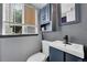Gray bathroom with stylish vanity, mirror, and window for natural light at 8710 Alta Vista Dr, Arvada, CO 80004