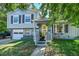Charming two-story home with a well-manicured lawn, gray siding, yellow door and an attached one-car garage at 8710 Alta Vista Dr, Arvada, CO 80004