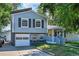 Two-story home with gray siding, dark shutters, an attached one-car garage, and a covered front porch with yellow front door at 8710 Alta Vista Dr, Arvada, CO 80004