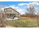 Green backyard featuring a covered patio area with outdoor seating and a wooden fence at 5264 E 129Th Pl, Thornton, CO 80241