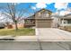Inviting two-story home with a well-manicured lawn, two-car garage, and charming front porch at 5264 E 129Th Pl, Thornton, CO 80241