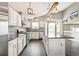 Bright kitchen with hardwood floors, stainless steel appliances, white cabinets, island and modern light fixtures at 5264 E 129Th Pl, Thornton, CO 80241