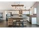 Bright kitchen with hardwood floors, stainless steel appliances, white cabinets, island and modern light fixtures at 5264 E 129Th Pl, Thornton, CO 80241