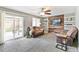 Cozy living room with comfortable seating, a sliding glass door to the patio, and a decorative wood accent wall at 5264 E 129Th Pl, Thornton, CO 80241