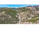 Breathtaking aerial view of mountain scenery with a road cutting through dense forests at 617 Hummingbird Trl, Idaho Springs, CO 80452