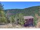 A charming home nestled on a mountainside, surrounded by lush trees and natural beauty at 617 Hummingbird Trl, Idaho Springs, CO 80452