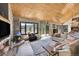 Cozy living room with a wood-paneled ceiling, fireplace, and a large window with views offering a warm and inviting atmosphere at 617 Hummingbird Trl, Idaho Springs, CO 80452