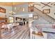 Open-concept living area features soaring ceilings, wood floors, staircase and seamless flow to the kitchen and dining space at 617 Hummingbird Trl, Idaho Springs, CO 80452