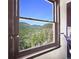 Window view framing a picturesque mountain vista with lush green trees under a clear blue sky at 617 Hummingbird Trl, Idaho Springs, CO 80452