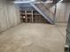 Basement with concrete floor, storage shelves, and metal staircase at 6961 E Arkansas Ave, Denver, CO 80224