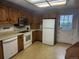 Well-lit kitchen with classic wooden cabinets and white appliances at 6961 E Arkansas Ave, Denver, CO 80224