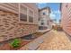 Backyard with brick, gravel, stepping stones and lawn visible from side of house at 21451 E 60Th Ave, Aurora, CO 80019