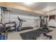 Unfinished basement featuring a treadmill, weightlifting station, weights and a black rubber floor at 21451 E 60Th Ave, Aurora, CO 80019