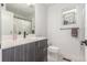 Modern bathroom featuring a sleek vanity, framed mirror, toilet, and a shower behind a curtain at 21451 E 60Th Ave, Aurora, CO 80019