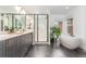 A beautifully designed bathroom with a dual vanity, freestanding tub, and a glass shower enclosure at 21451 E 60Th Ave, Aurora, CO 80019