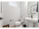 Contemporary half bathroom featuring a pedestal sink, sleek fixtures, and minimalist decor at 21451 E 60Th Ave, Aurora, CO 80019