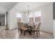 Well-lit dining area featuring a dark wood table with seating for six beneath a modern chandelier at 21451 E 60Th Ave, Aurora, CO 80019
