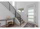 Bright foyer with modern staircase, featuring a glass front door and sleek design elements at 21451 E 60Th Ave, Aurora, CO 80019