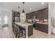 Modern kitchen with stainless steel appliances, a large island, and stylish pendant lighting at 21451 E 60Th Ave, Aurora, CO 80019