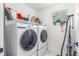 Efficient laundry room with white Samsung washer and dryer set and storage shelves at 21451 E 60Th Ave, Aurora, CO 80019