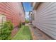 Narrow side yard with artificial turf, stepping stones, mulch, and lush greenery at 21451 E 60Th Ave, Aurora, CO 80019