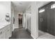 Modern bathroom featuring glass shower, dark tile, and entrance to walk-in closet at 9021 Swan River St, Littleton, CO 80125