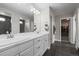 Bright bathroom features double vanity, black tile floor, and large mirror at 9021 Swan River St, Littleton, CO 80125
