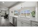 Kitchen sink with view to outdoor patio, stainless steel appliances, and adjacent living area at 9021 Swan River St, Littleton, CO 80125
