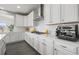 Close-up of kitchen countertops with white cabinetry, modern appliances, and stainless steel vent hood at 9021 Swan River St, Littleton, CO 80125